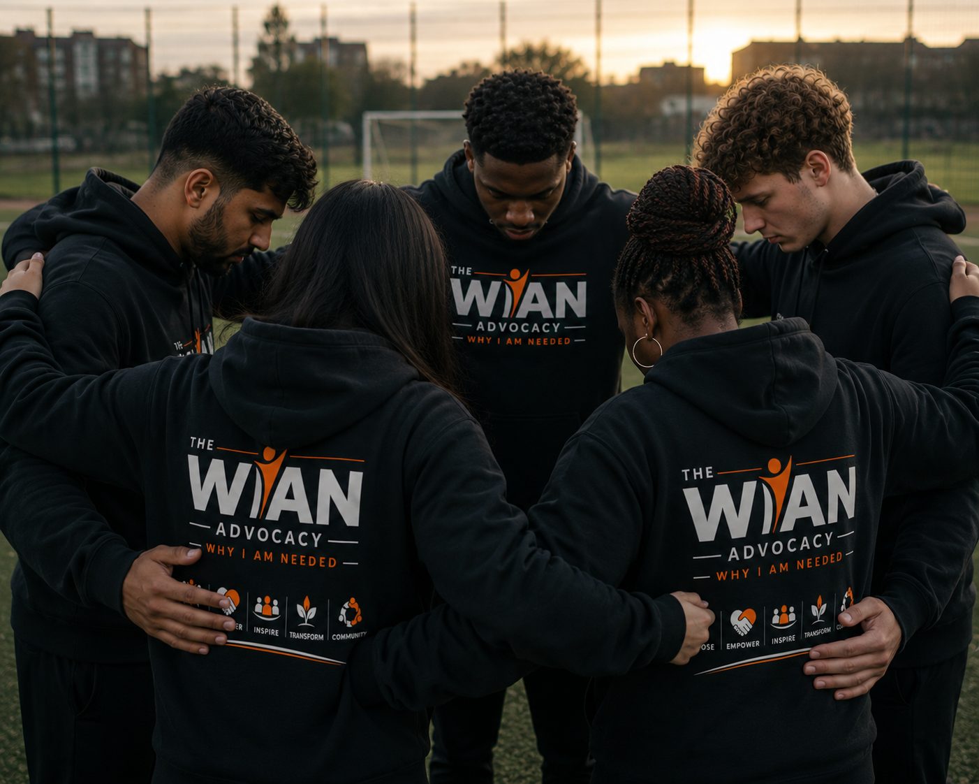 Group of young people from The WIAN Advocacy raising their arms at sunset, wearing WIAN branded hoodies, with the words Building futures, Inspiring purpose, Creating leaders